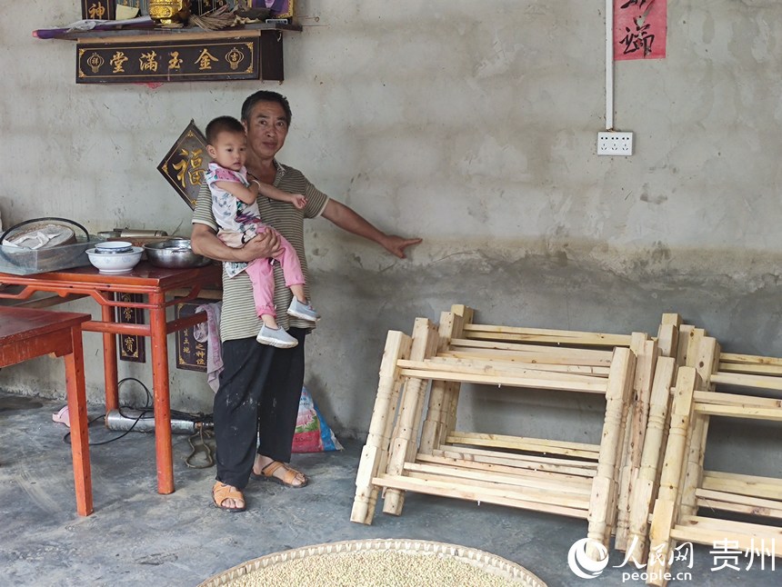 明星居村民第二天返回家里自救物資,村民所指位置為日前洪水到達他家的水位高度。人民網 唐杰攝