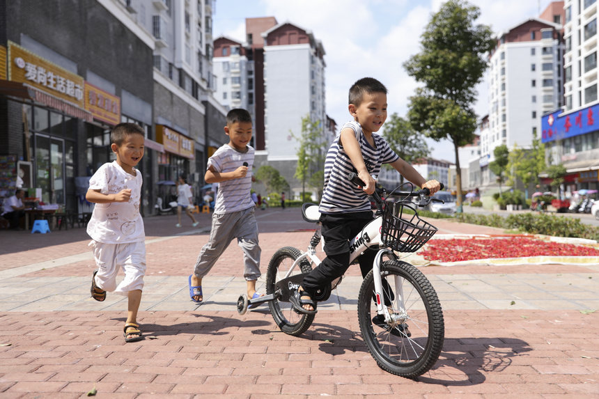 2021年8月21日,務(wù)川自治縣大坪街道敬賢社區(qū)易地扶貧搬遷安置點(diǎn)的小朋友在小區(qū)玩耍。