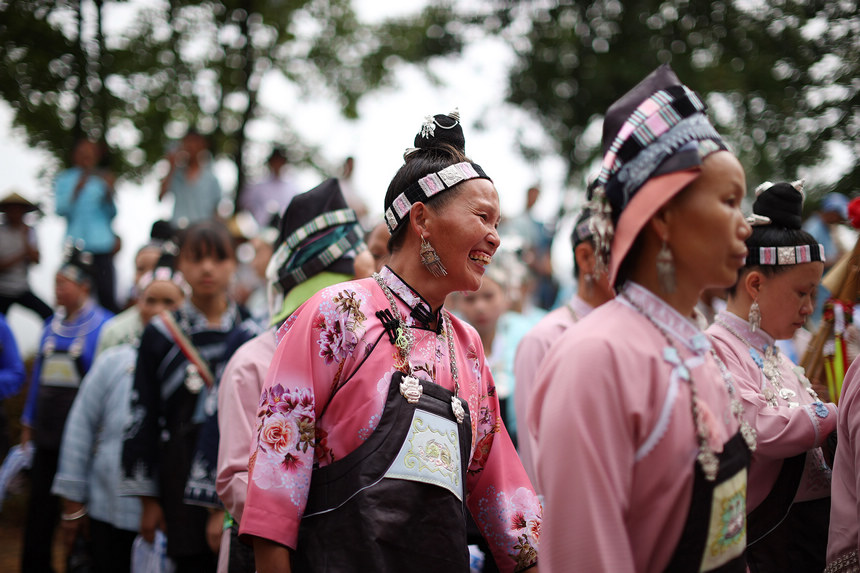 8月5日，盛裝打扮的苗族村民在山頂上跳蘆笙舞。