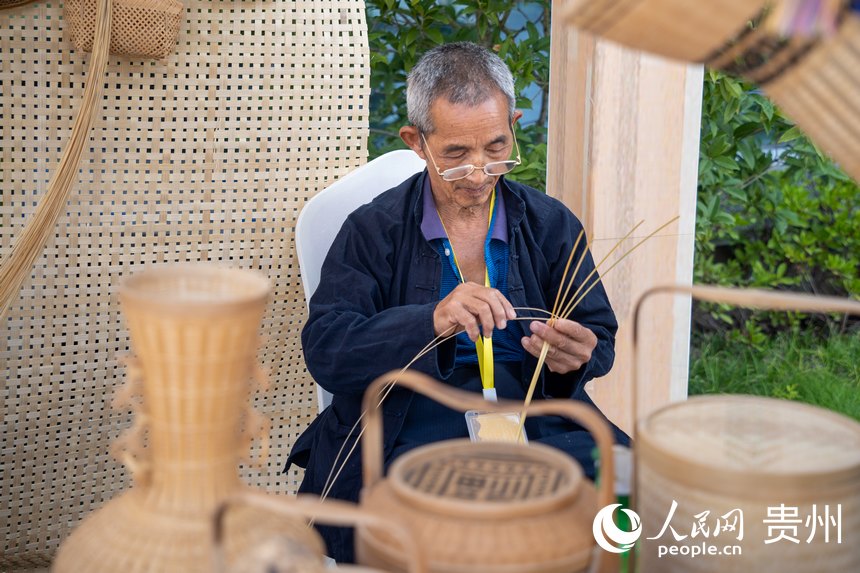 山地生活消費與非遺傳承展現場，非遺技藝三穗竹編傳承人展示竹編技藝。人民網 涂敏攝