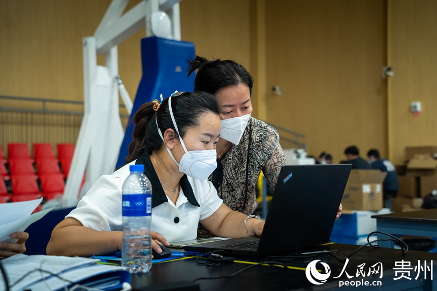 貴陽市第二人民醫院檢驗科主任袁軍（右）正與同事討論檢驗問題。人民網 涂敏攝