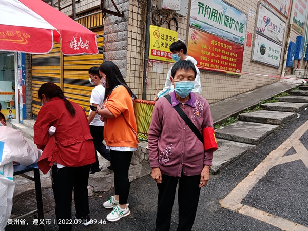 退干部張德碧堅守社區路口(右一）。