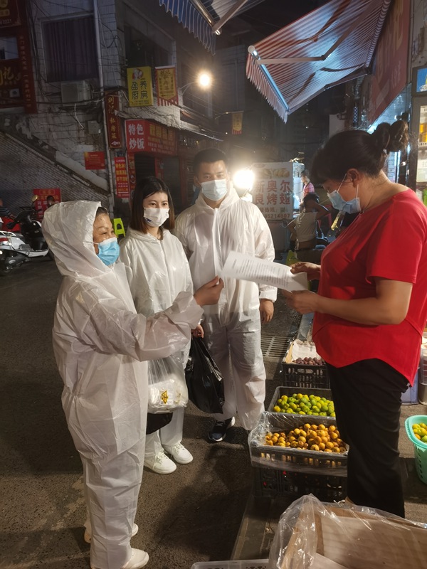 閔紅為居民介紹抗原試劑說明（左一）。