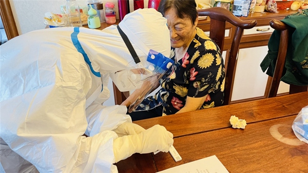 2 對于不會操作小程序及不會抗原自測的老年人，小區志愿者上門幫助他們完成檢測。受訪者供圖