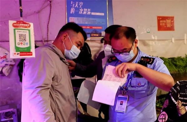 1 執法人員在碧潭園小區附近某生鮮店內查看相關單據。