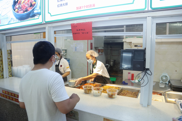 貴州醫科大學學生在“貴醫愛心餐”供應窗口取餐。