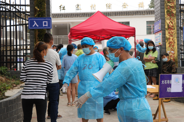 楊正文(右一)在核酸檢測現(xiàn)場維持秩序。鐘正超攝