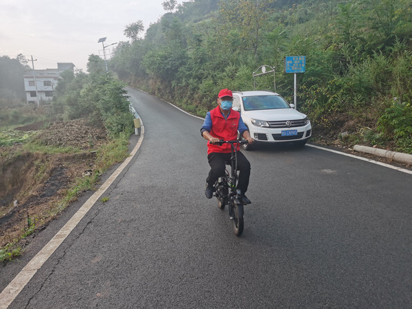 楊正文騎著電動自行車宣傳疫情防控。楊正文攝