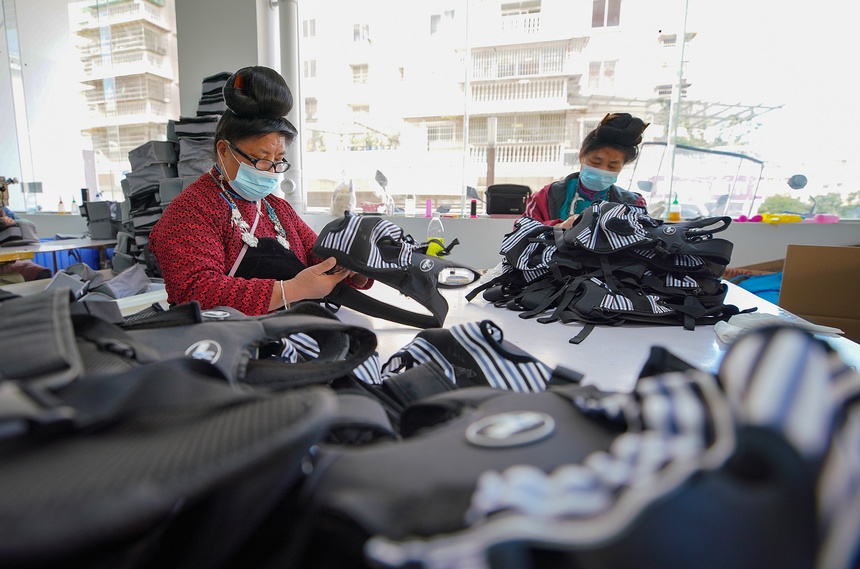 10月11日，工人在移民安置社區(qū)“幫扶車間”檢查背包成品質(zhì)量。