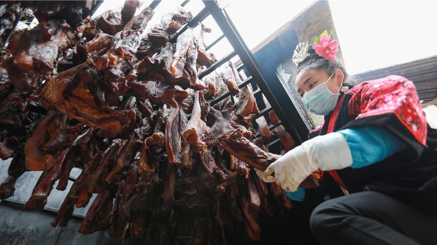 2023年1月2日，苗族群眾在查看臘肉熏制情況。