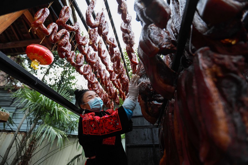 2023年1月2日，苗族群眾在查看臘肉熏制情況。