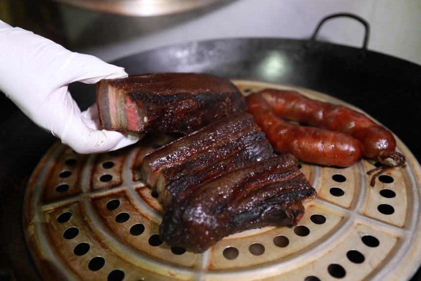 2023年1月2日，苗族群眾在蒸臘肉。