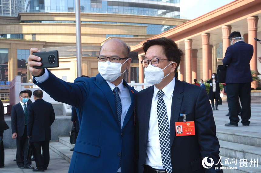 政協委員站在會議中心門口合影留念。人民網 陽茜攝