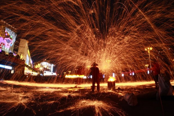 表演者用鐵鍬將高溫鐵水拋向空中。蘇陽攝
