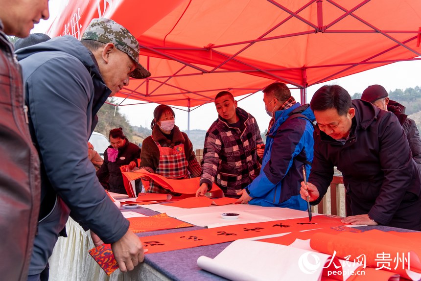 書法愛好者為村民書寫春聯。人民網 涂敏攝