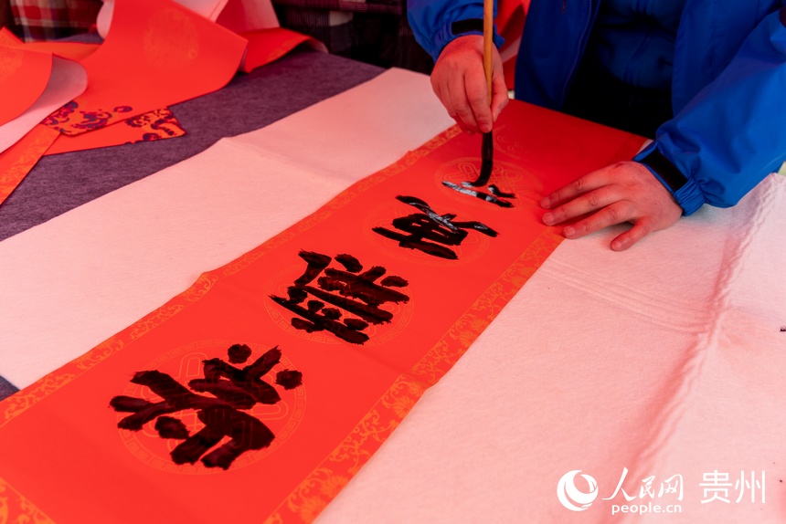 書法愛好者為村民書寫春聯。人民網 涂敏攝