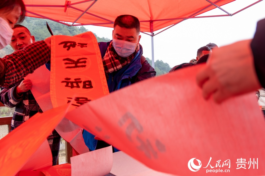 書法愛好者為村民書寫春聯。人民網 涂敏攝