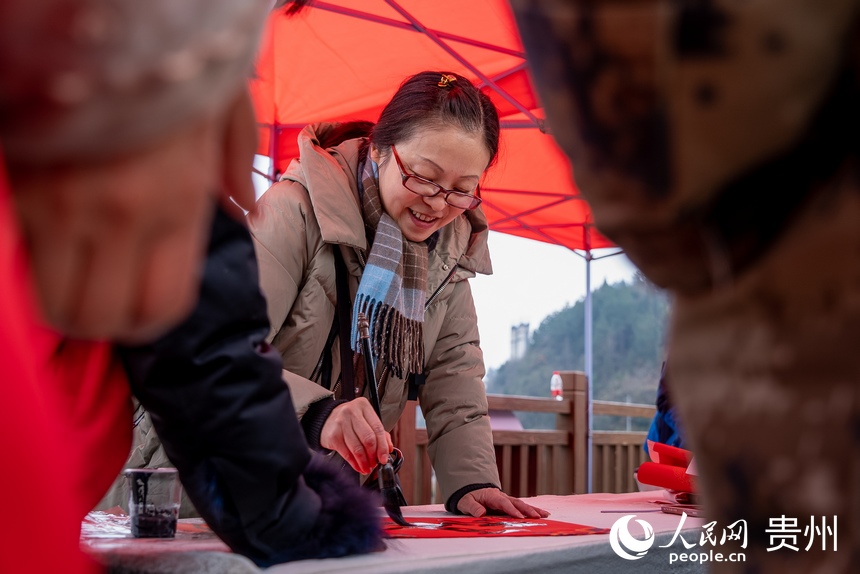 書法愛好者為村民書寫春聯(lián)。人民網(wǎng) 涂敏攝