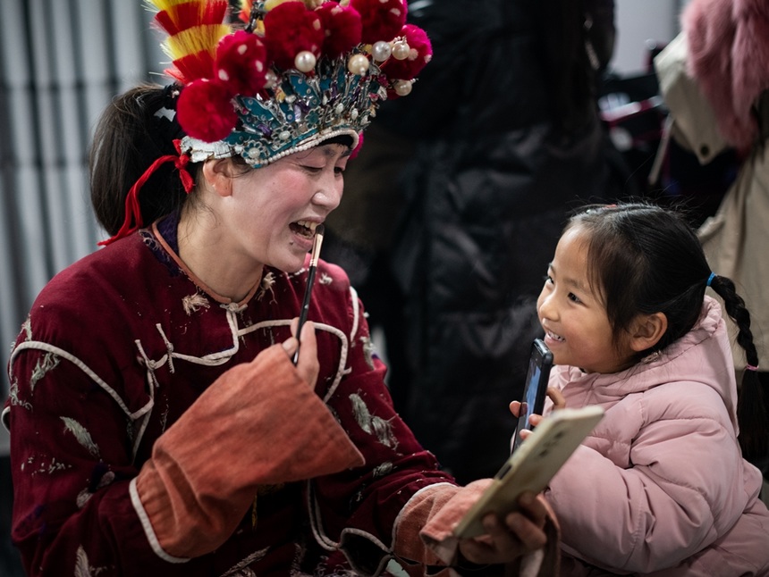 漢寨侗戲班演員與小孩互動。