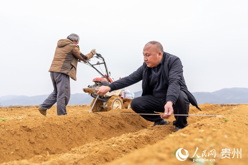 農業技術員查看村民起壟。人民網 涂敏攝