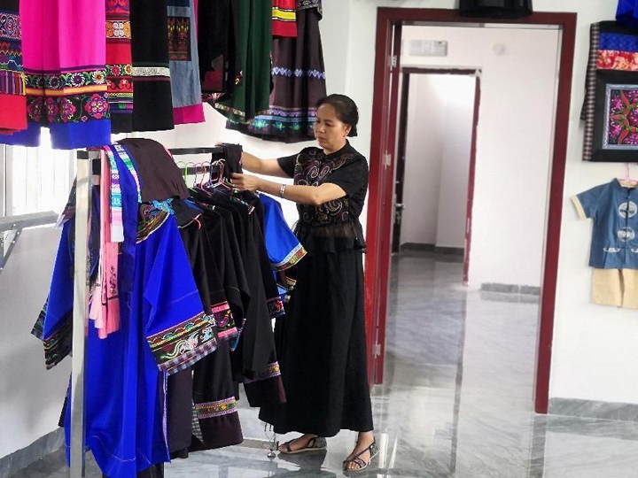 潘明飛整理民族服飾。受訪者供圖