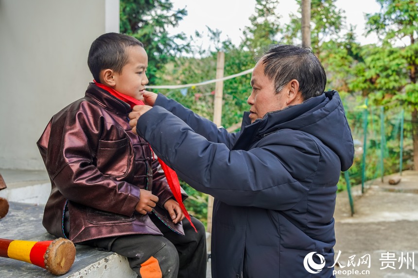 孟榮達老師正在為孩子系紅領巾。人民網 陽茜攝