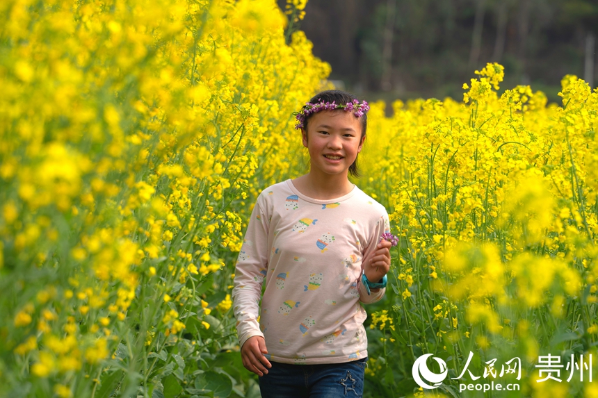 游客走在花田道里與油菜花親密接觸。人民網(wǎng) 陽(yáng)茜攝