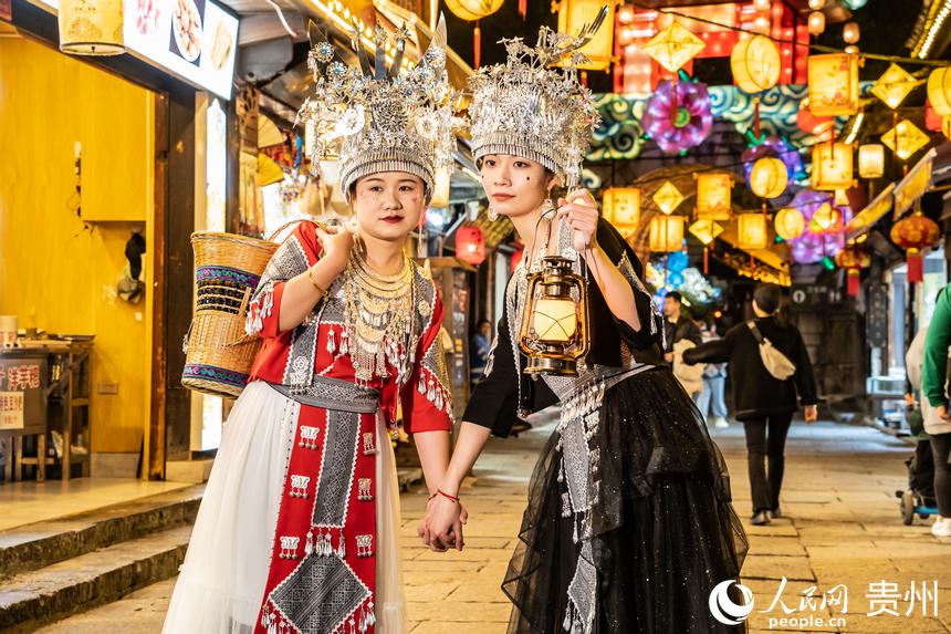 游客身著民族服飾站在古鎮街道上合影。人民網 陽茜攝