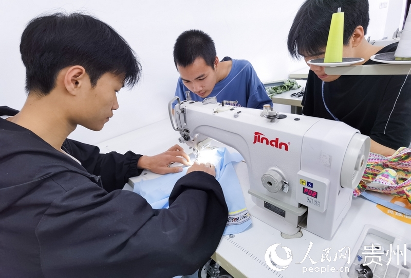 民族服飾實操教室內，同學們正在做衣服。人民網 王秀芳攝