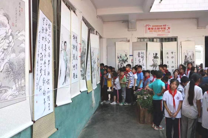 圖為黔西南州老年書畫研究會在興義市烏沙鎮中心小學開展“送書畫進校園”主題活動。