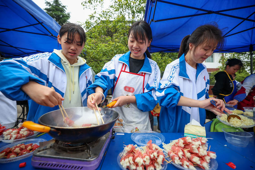 高三年級學生在“校園美食節”上烹飪美食。楊勝賢攝
