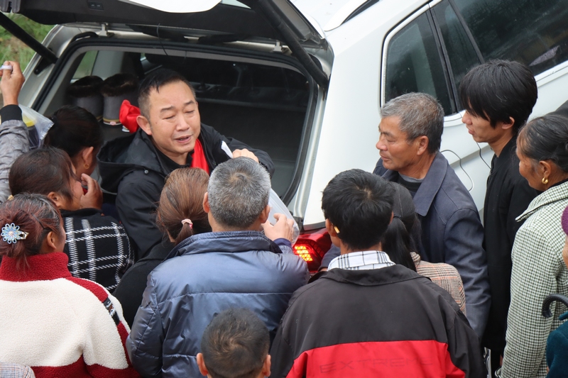 村民提著土特產(chǎn)前來送別莫書記。柏玉迪 攝