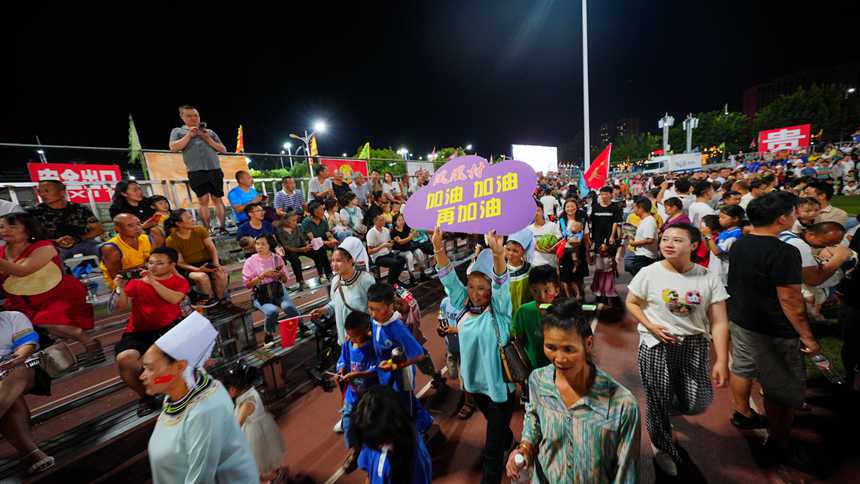 村民手舉加油牌為本村球員加油。周光勝攝