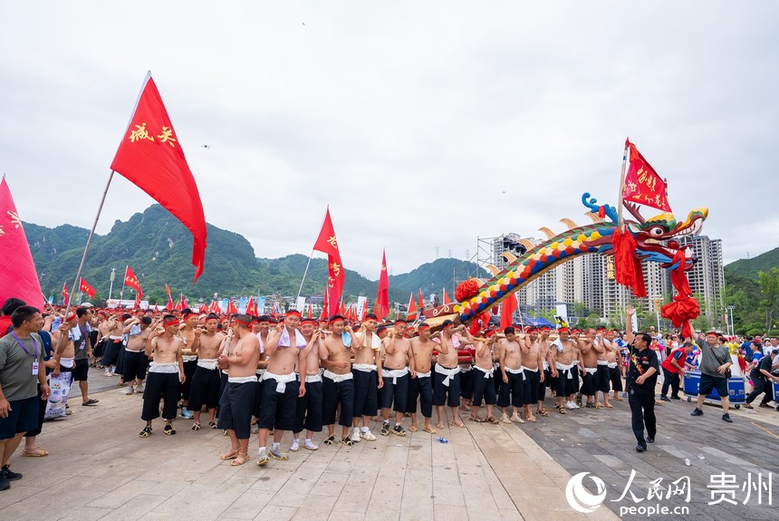 2000余名壯漢抬著長達98.8米的獨木龍舟巡游。人民網記者 涂敏攝