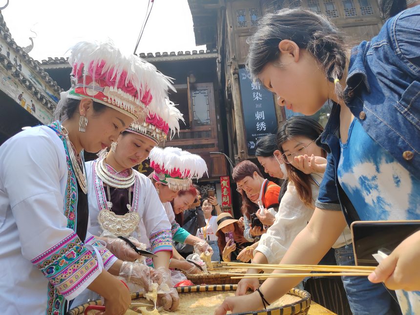 游客參與制作甜粑。