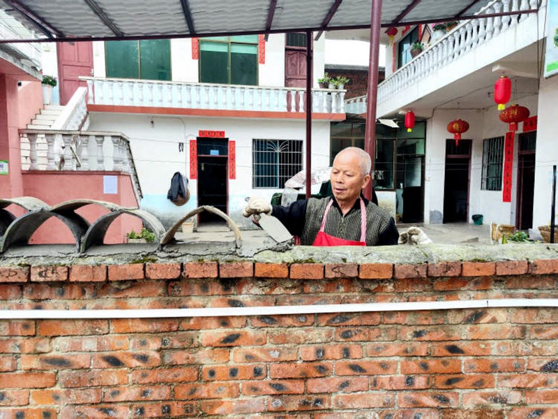 冠山街道三合社區老堡群眾正在用舊瓦片砌花式圍墻。龍里縣委宣傳部供圖