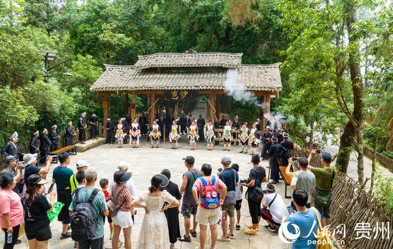 在岜沙苗寨,當地苗族同胞在寨門迎接游客。 人民網 陽茜攝