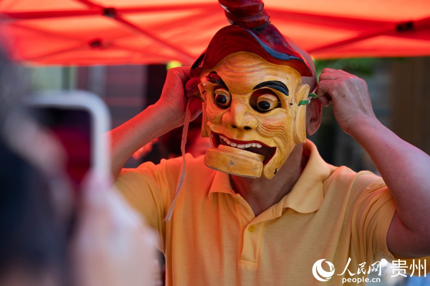 游客試戴儺戲面具。人民網 陽茜攝