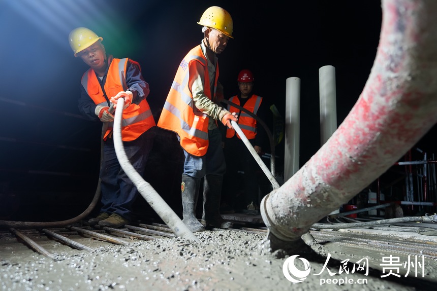 工人正在進行合龍段混凝土澆筑施工。人民網(wǎng)記者 涂敏攝