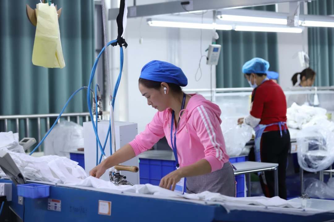  圖為工人熨燙衣物。