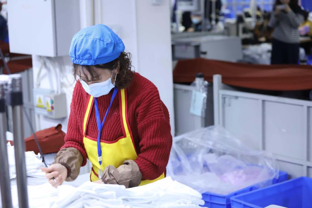  圖為工人對衣物進行質檢。