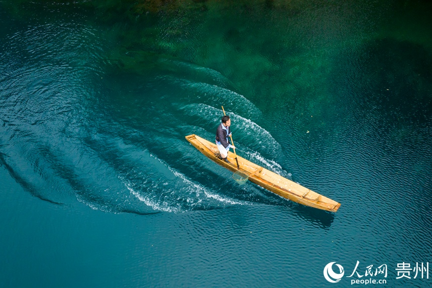 景區工作人員在臥龍潭上工作也成為一道美麗的風景。人民網記者 涂敏攝