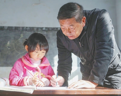 李明軍（右）在輔導學生做作業。