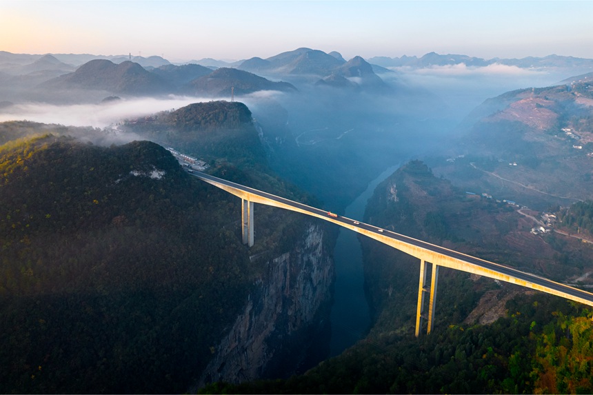 11月28日清晨，貴畢公路六廣河特大橋與云海、山川交相輝映，構成一幅壯美的交通畫卷。