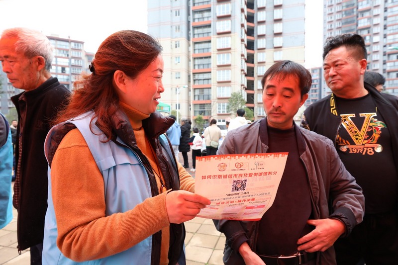 (4)2023年12月9日，清鎮市鄉愁社區云夢小鎮。圖為活動現場志愿者向小區居民宣傳普及信用知識。（任芳靚 攝）.jpg