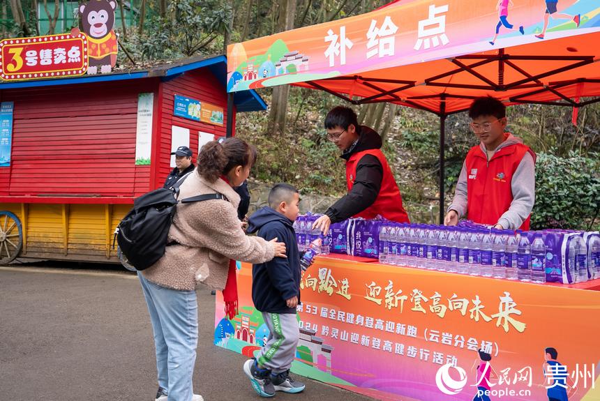 參與貴陽貴安第53屆全民健身登高迎新跑的市民領取補給。人民網記者 涂敏攝