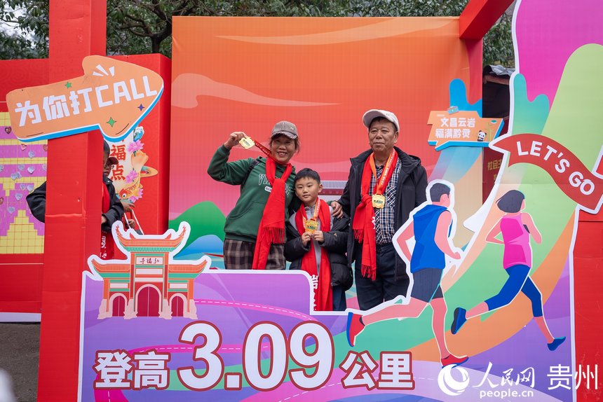 參與貴陽(yáng)貴安第53屆全民健身登高迎新跑的市民在終點(diǎn)打卡拍照。人民網(wǎng)記者 涂敏攝