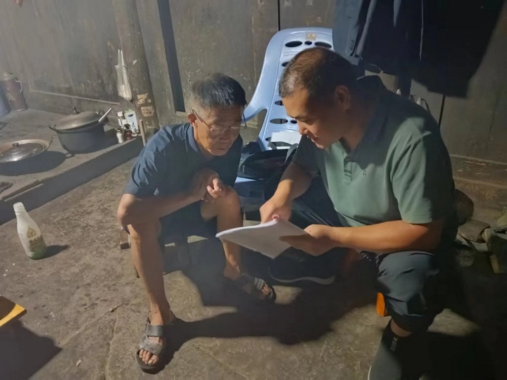 李云(右)進村入戶宣傳政策。貴旅集團供圖