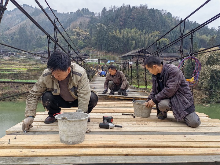 村民在修繕吊橋。董林丹攝