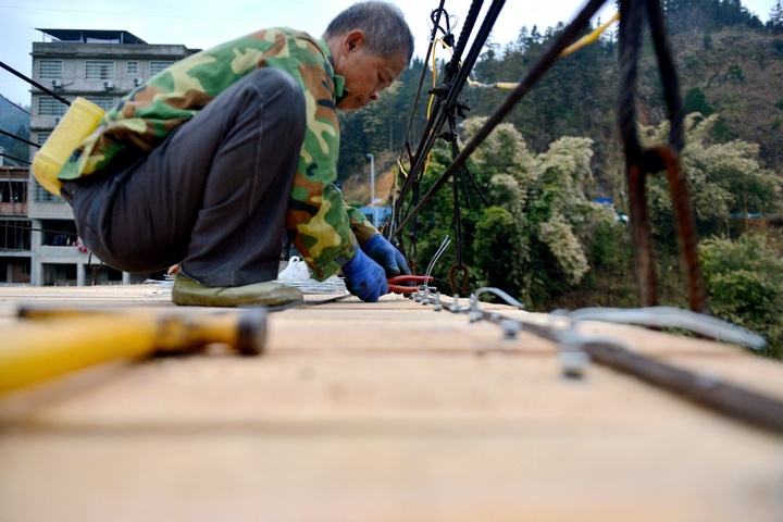 村民在修繕吊橋。胡濤攝